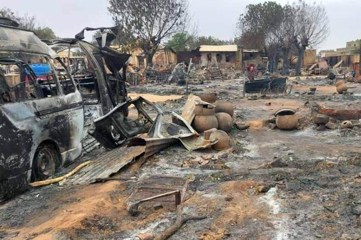 A burned vehicle amid a desolate landscape