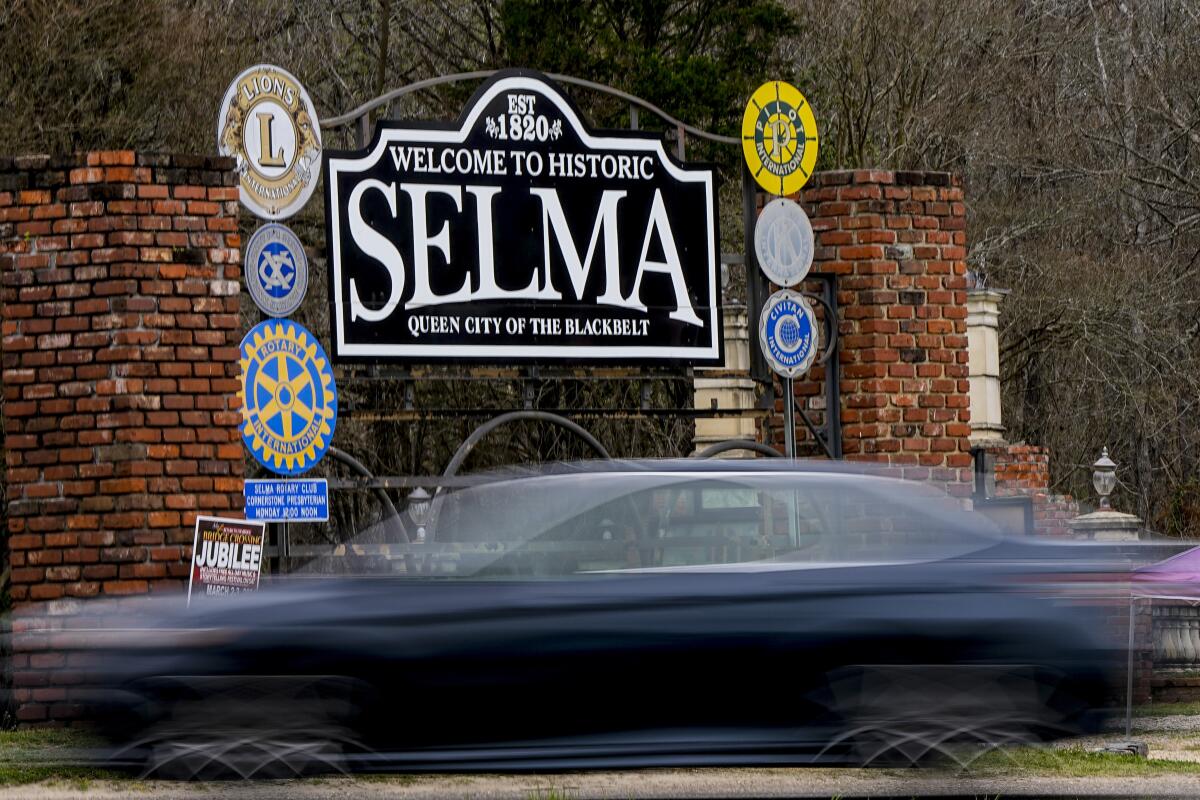 A vehicle passes by the town welcome sign in Selma, Ala.