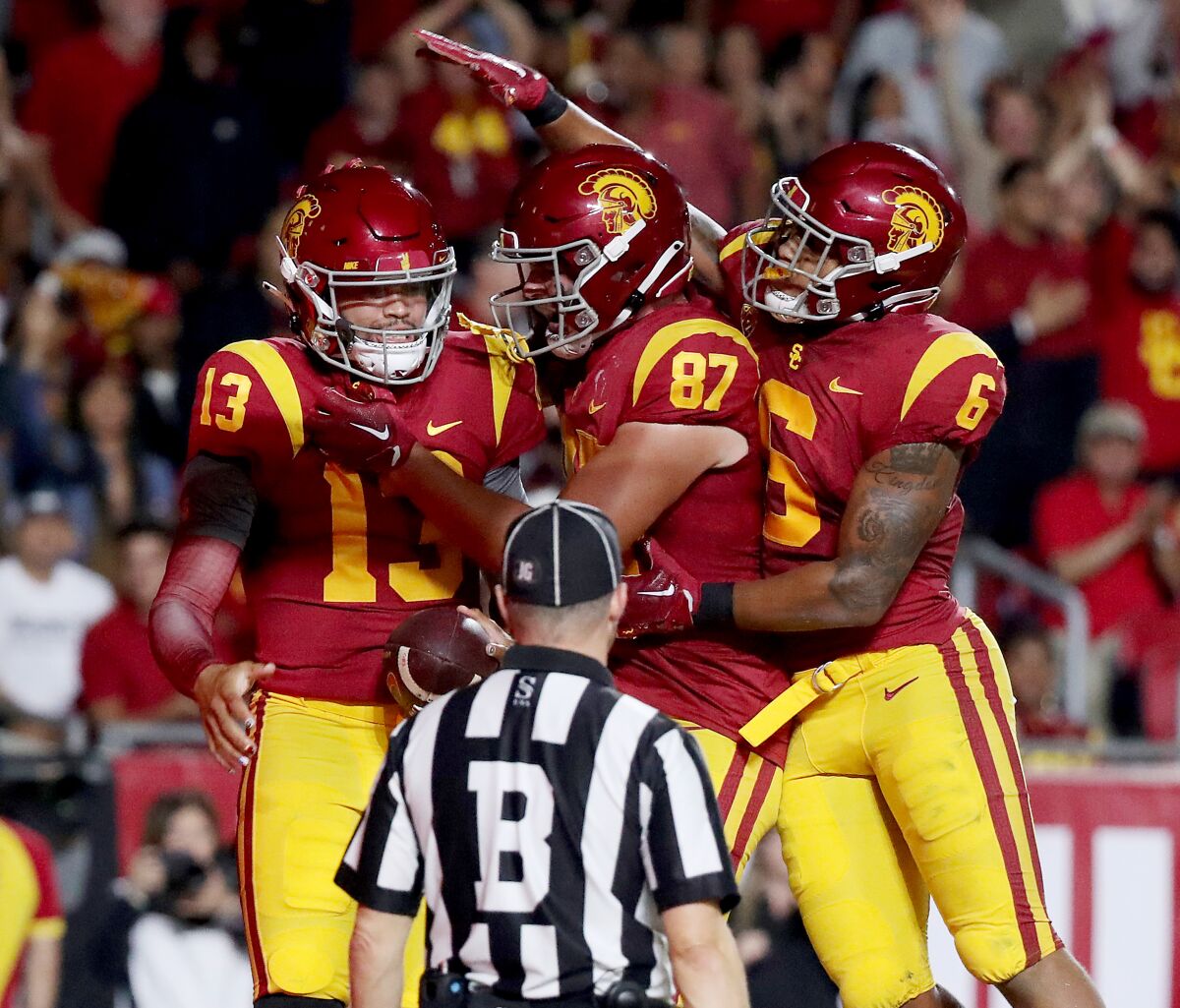 USC quarterback Caleb Williams is congratulated by teammates after scoring a touchdown.