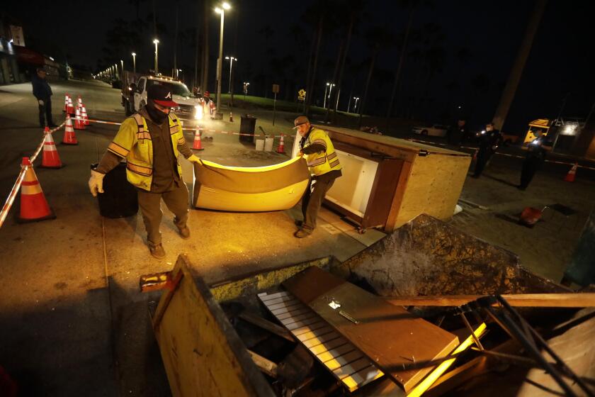 VENICE, CA - JULY 8, 2021 - - Sanitation workers clear a homeless encampment along Ocean Front Walk around 5 a.m. in Venice on July 8, 2021. Sanitation crews, working alongside L.A.P.D. officers and workers with St. Joseph Center, were clearing encampments between Windward Ave. and Park Ave along the boardwalk. (Genaro Molina / Los Angeles Times)