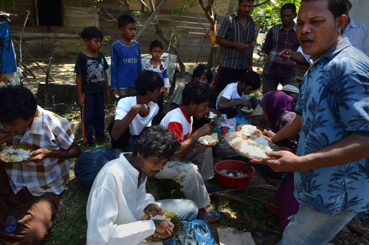 Indonesian residents hand food to a group of Rohingya men from Myanmar in the compound of a mosque in Aceh province on May 20.