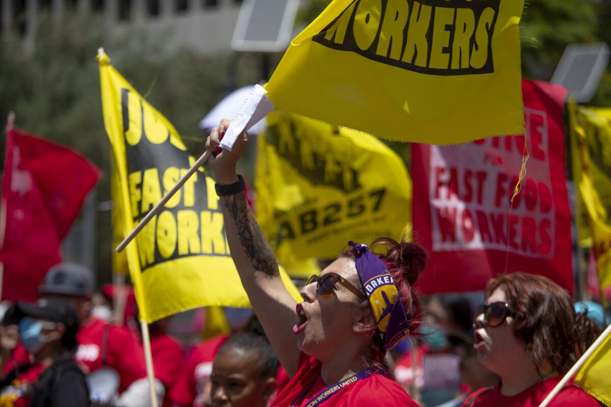 A fast-food worker  shouts slogans at a rally 