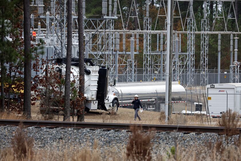 Workers work on equipment at the West End Substation, at 6910 NC Hwy 211 in West End, N.C., Monday, Dec. 5, 2022, where a serious attack on critical infrastructure has caused a power outage to many around Southern Pines, N.C. (AP Photo/Karl B DeBlaker)