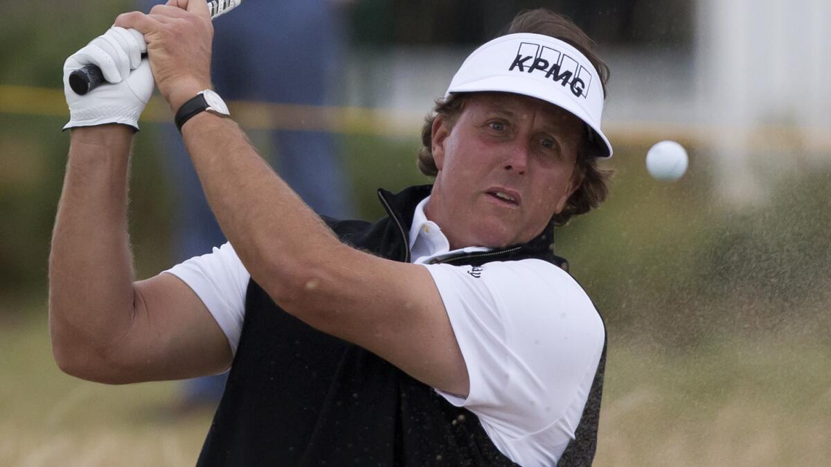 Phil Mickelson plays out of a bunker near the second green during a practice round at Royal Liverpool Golf Club on Monday. Mickelson wants to turn his season around this week at the British Open.