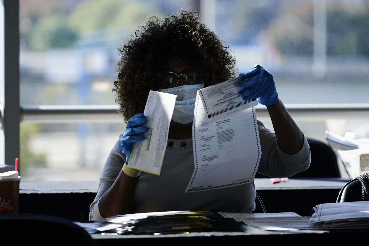 An election worker examines a ballot.