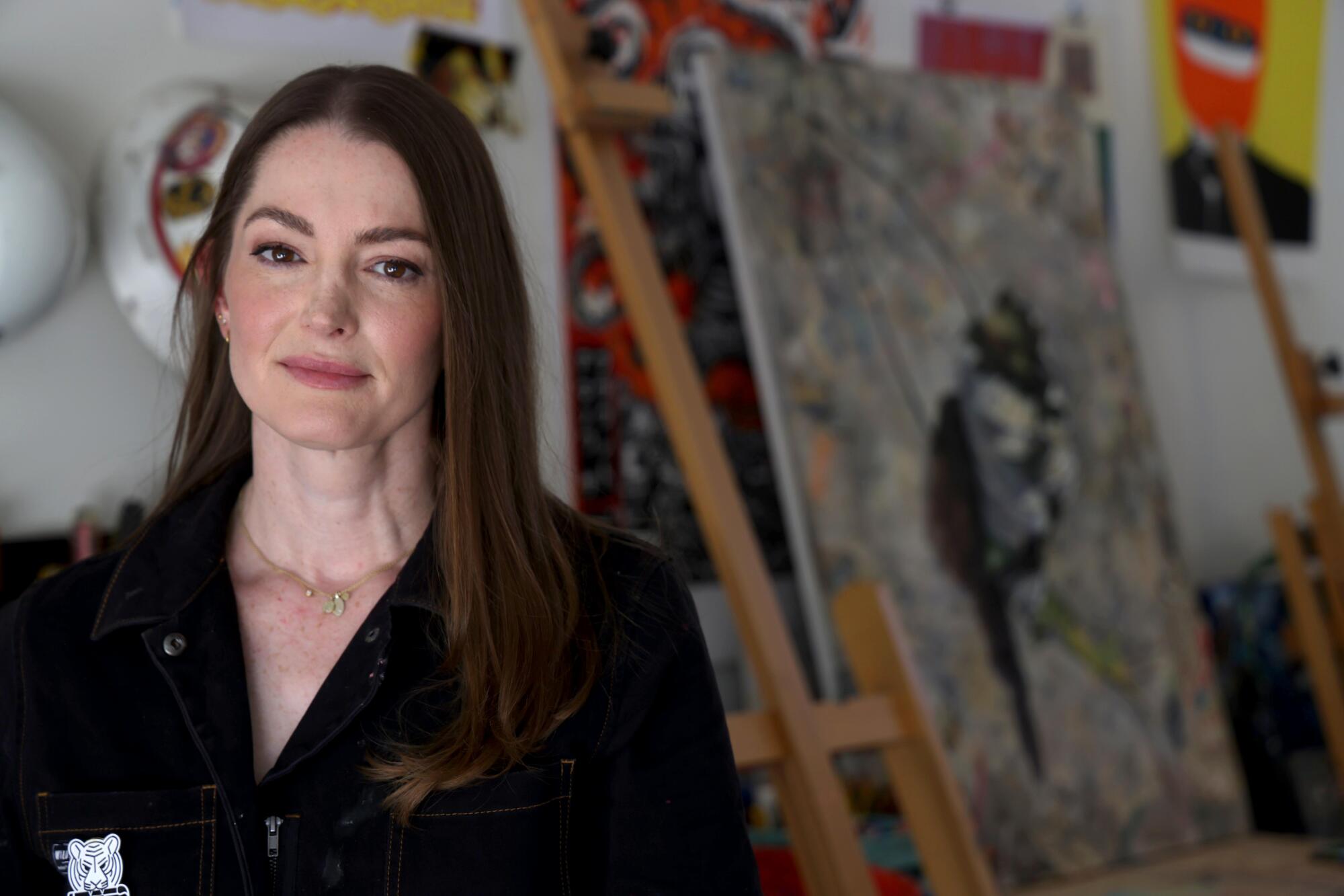 Miriam Hellmann stands in her garage, surrounded by artwork done by her as well as other scenic painters.