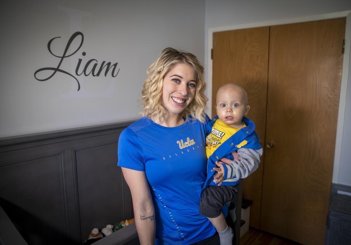 UCLA gymnast Mercedez Sanchez holds her baby brother Liam Clark.