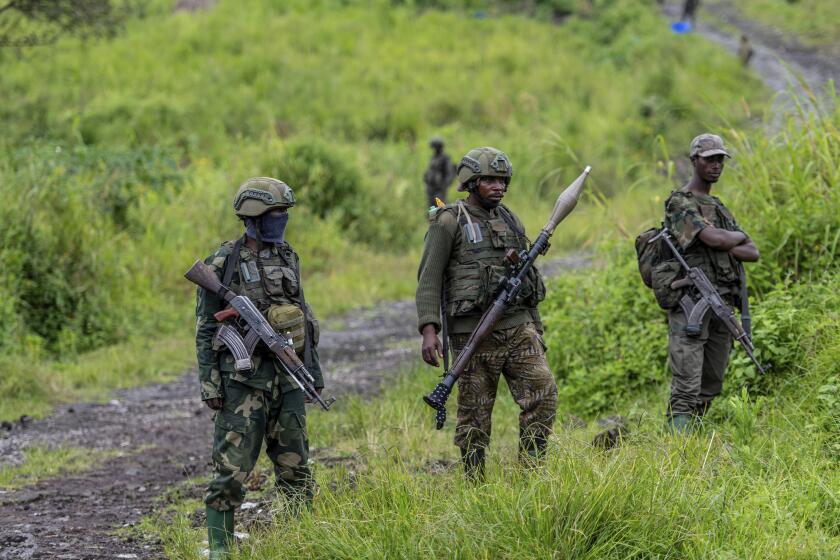 FILE - M23 rebels stand with their weapons in Kibumba, in the eastern of Democratic Republic of Congo, Dec. 23, 2022. A bomb at a refugee camp in eastern Congo has killed at least 5 people, including children, a spokesman for the Congolese army said on Friday May 3, 2024. Lt Colonel Ndjike Kaiko, the army spokesman blamed the attack on the Mugunga refugee camp in North Kivu on a a rebel group with alleged links to Rwanda, known as M23, in a statement provided to The Associated Press. (AP Photo/Moses Sawasawa, File)