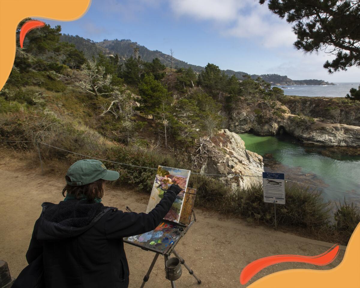 A person sits at an easel that's set up along a dirt path. 