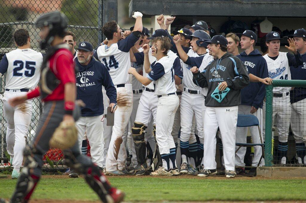 Corona del Mar's JT Schwartz gets high fives from his team after hittinga two-run home run in the fifth against Woodbridge in a Pacific Coast League game on Tuesday.