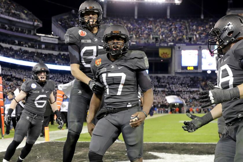 Army quarterback Ahmad Bradshaw (17) celebrates what proved to be the game-winning touchdown against Navy with teammates late in the fourth quarter Saturday.