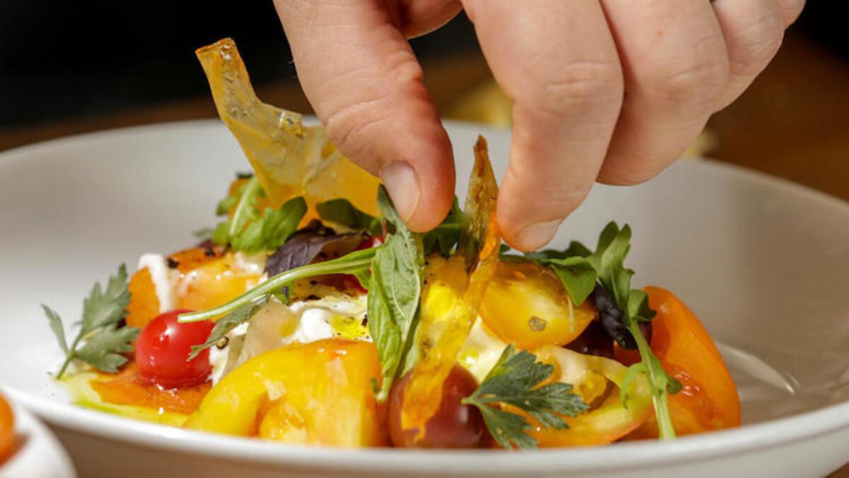 Chef Bruce Kalman, prepares Caprese Salad, made with dehydrated roasted tomato skin chips, at Union Restaurant in Pasadena.
