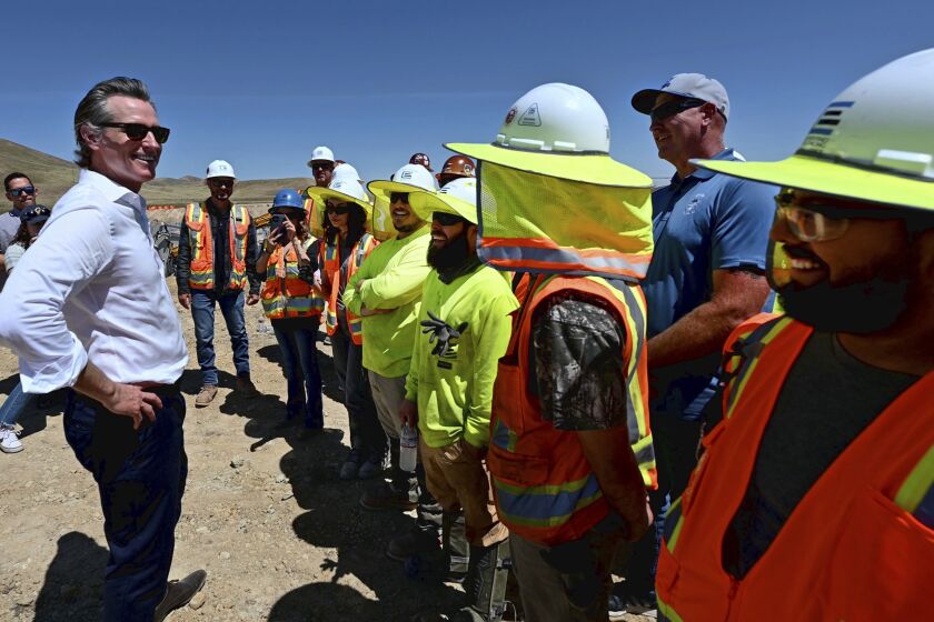 FILE – California Gov. Gavin Newsom talks with union electricians at Proxima Solar Farm outside Patterson, Calif., on May 19, 2023. California has struggled to meet growing demand for electricity as the state transitions away from fossil fuels. Gov. Newsom has proposed the purchasing power of the state to purchase large amounts of new renewable energy, including from offshore wind and geothermal power plants. (Andy Alfaro/The Modesto Bee via AP, File)