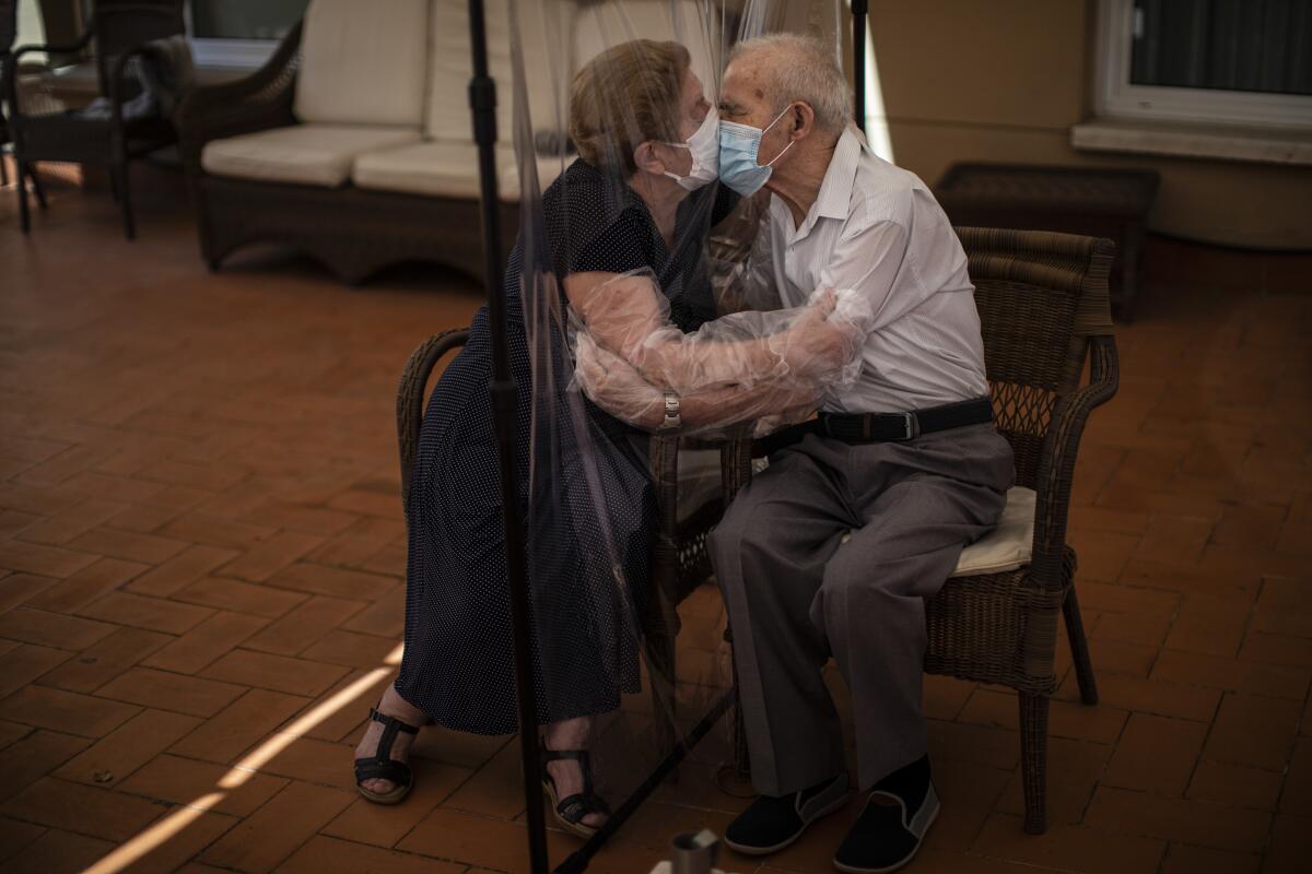 Agustina Cañamero, 81, hugs and kisses her husband Pascual Pérez, 84, through a plastic film screen to avoid contracting the coronavirus at a nursing home in Barcelona, Spain, June 22, 2020. Even when it comes wrapped in plastic, a hug can convey tenderness and relief, love and devotion. The fear that gripped Agustina Cañamero during the 102 days she and her 84-year-old husband spent physically separated during Spain's coronavirus outbreak dissolved the moment the couple embraced through a screen of plastic film. The image was part of a series by Associated Press photographer Emilio Morenatti that won the 2021 Pulitzer Prize for feature photography. (AP Photo/Emilio Morenatti)