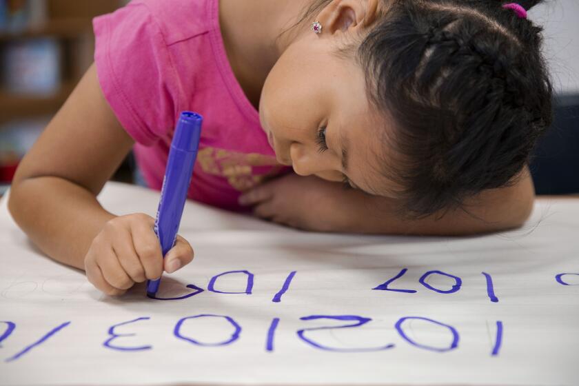 LOS ANGELES, CALIF. - AUGUST 06, 2019: Emily Osorio-Hernandez, 6, writes numbers for a math assignment at Esperanza Elementary School on Tuesday, Aug. 6, 2019 in Los Angeles, Calif. L.A. Unified is running a new summer program for incoming first graders who are slightly behind academically to ensure they catch up and don't need more interventions and credit recovery when they're older. (Liz Moughon / Los Angeles Times)