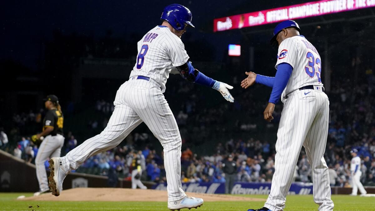 The Chicago Cubs' Seiya Suzuki (R) is congratulated by first base