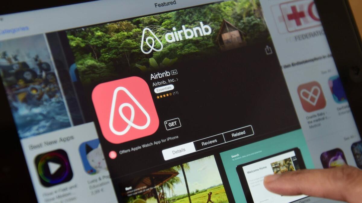 A person browses the Airbnb website on a tablet.