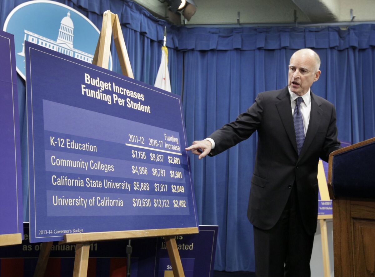 Gov. Jerry Brown points to a chart showing an increase in education funding during a news conference where he unveiled his proposed 2013-14 state budget at the Capitol in January.