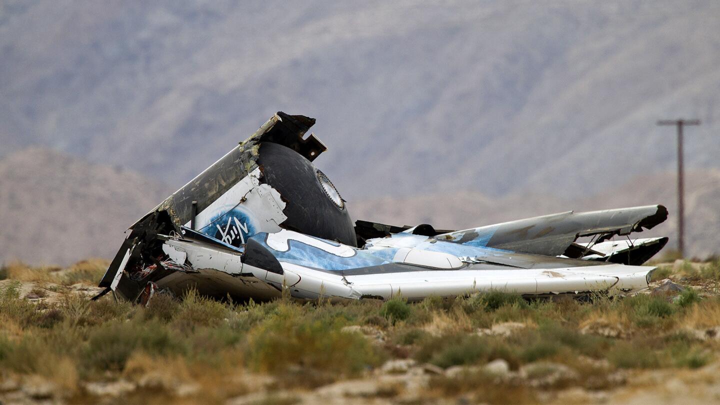 Wreckage from Virgin Galactic's SpaceShipTwo rests in desert terrain.