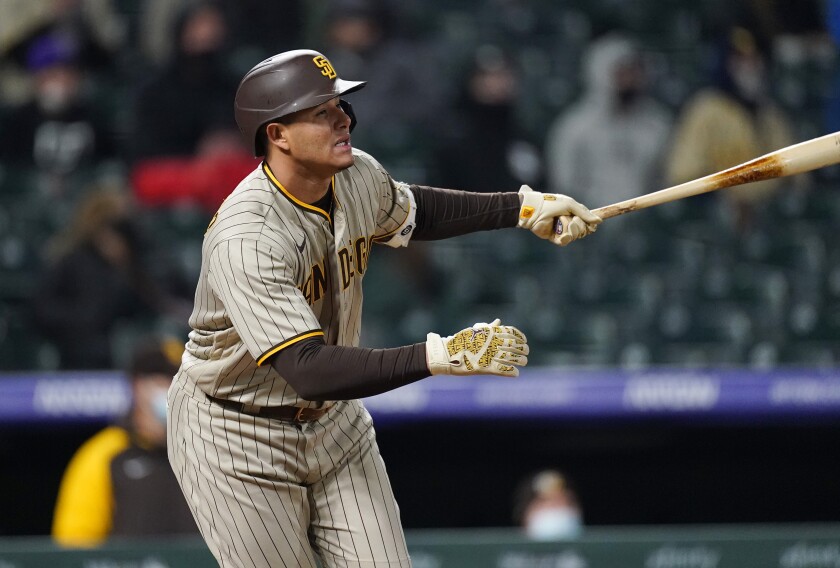 San Diego Padres' Manny Machado watches his three-run triple off Colorado Rockies relief pitcher Tyler Kinley during the sixth inning of a baseball game Tuesday, May 11, 2021, in Denver. (AP Photo/David Zalubowski)