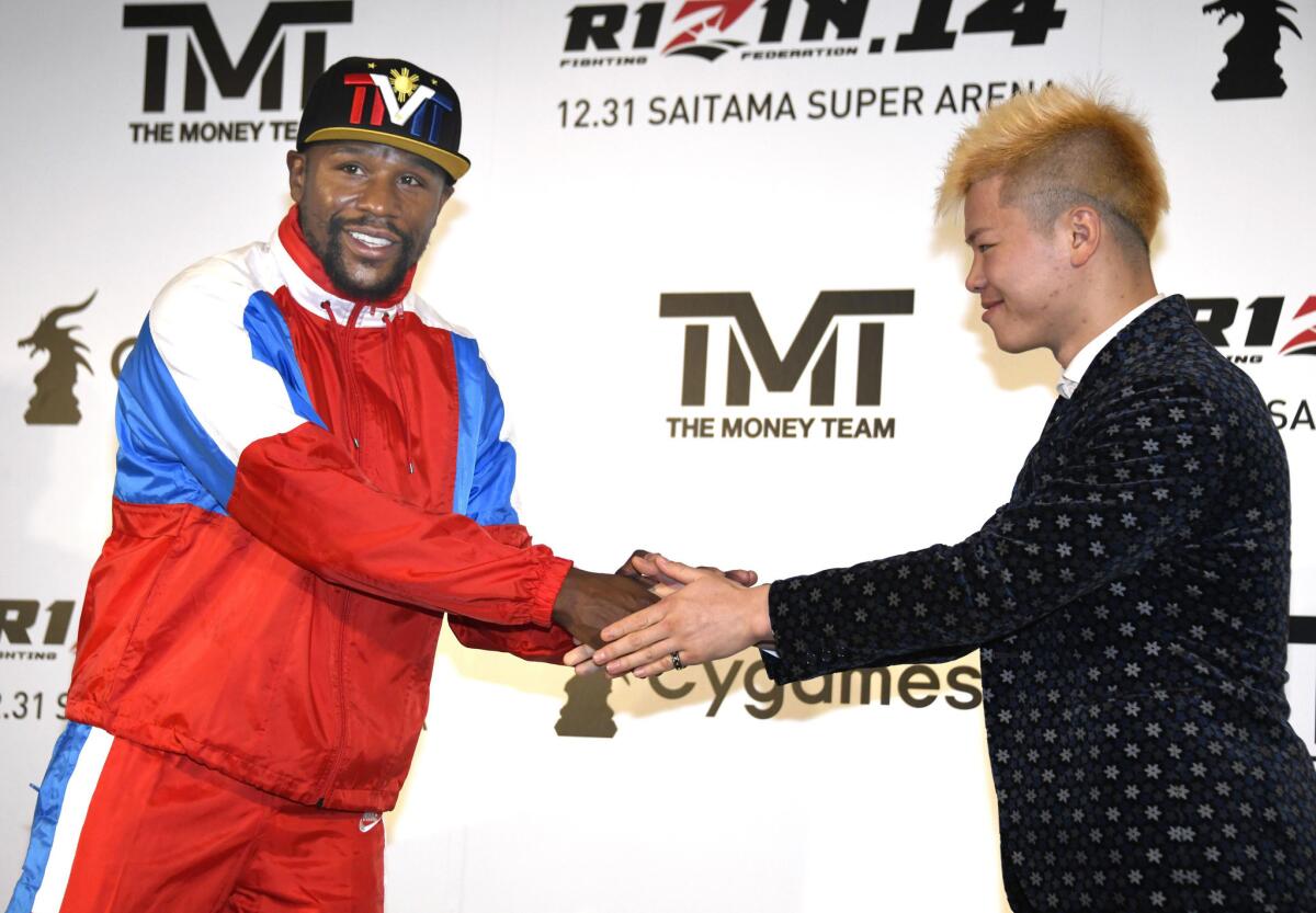 El exboxeador Floyd Mayweather, izquierda, estrecha la mano del japonés experto en kickboxing Tenshin Nasukawa durante una conferencia de prensa en Tokio, el lunes 5 de noviembre de 2018.