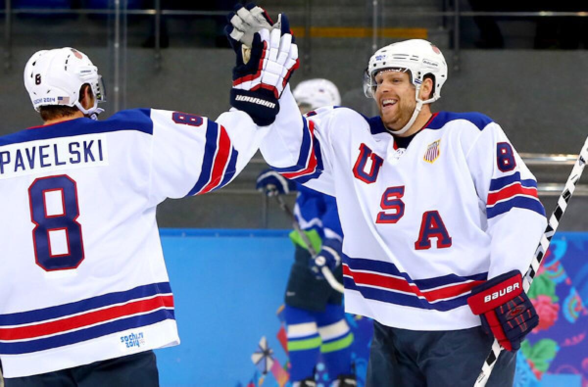 U.S. forward Phil Kessel is congratulated by teammate Joe Pavelski after scoring his second goal in the first period against Slovenia in a preliminary-round game of the Sochi Olympics on Sunday at Shayba Arena.