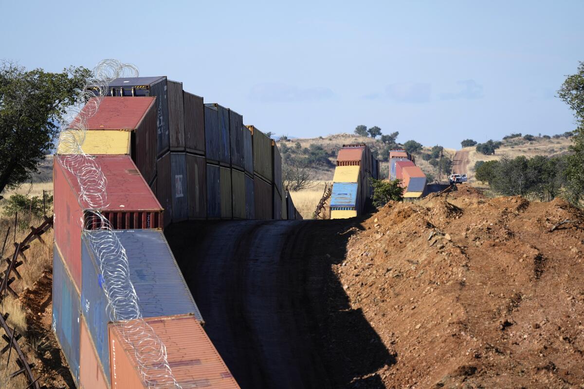 Long row of double-stacked shipping containers along Arizona-Mexico border