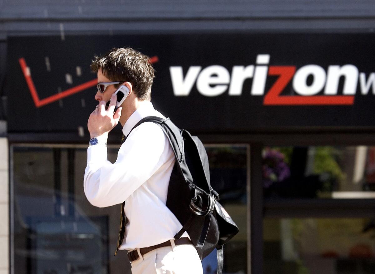 A man walks past a Verizon Wireless store in Portland, Ore.