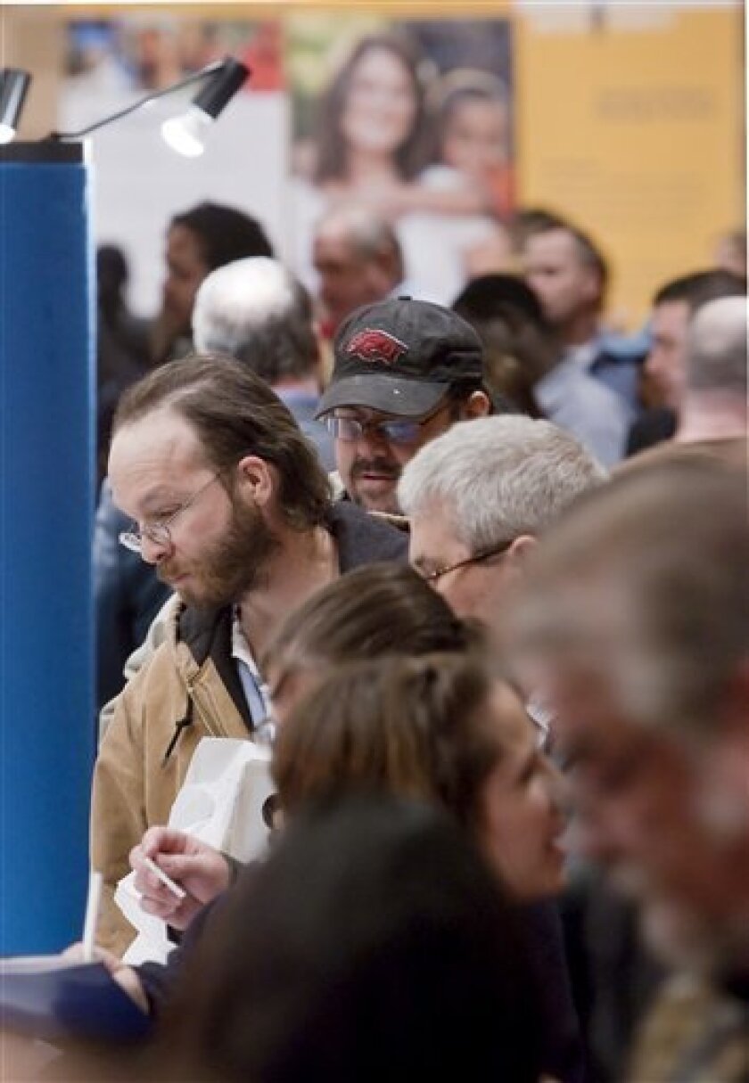 Jobseekers crowd around booths offering employment, at a job fair in Omaha, Neb., Wednesday, April 8, 2009. New jobless claims fell more than expected last week, while those continuing to receive unemployment insurance set a record for the 11th straight week. (AP Photo/Nati Harnik)