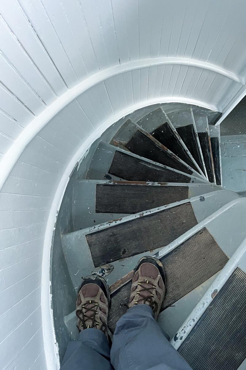A man's feet on a spiral staircase, photographed from above