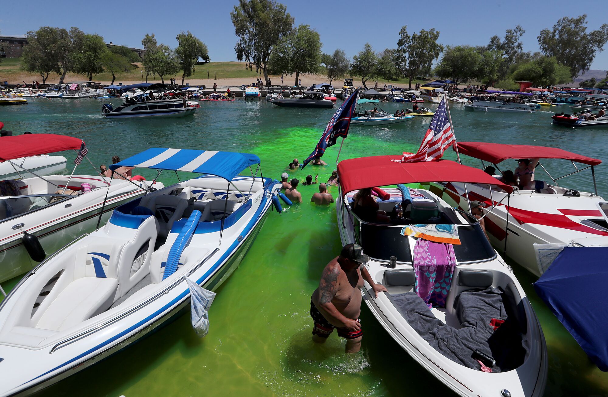 Holiday weekend visitors park their boats along the shore in Lake Havasu City, Ariz.,