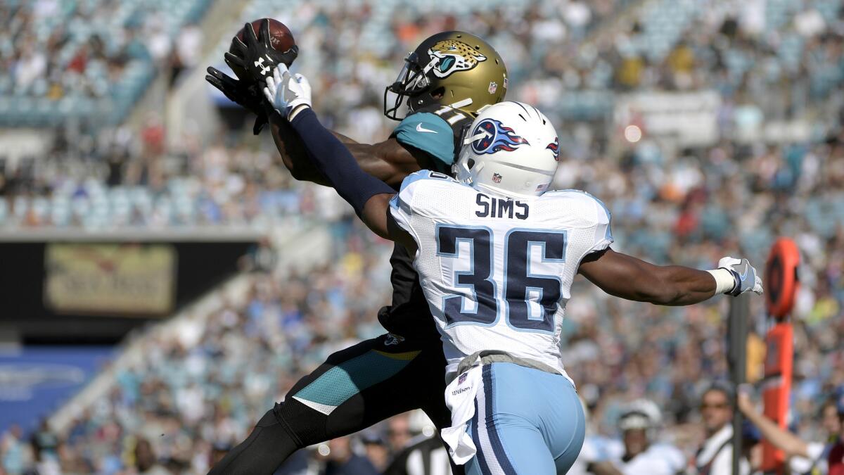 Jaguars receiver Marqise Lee catches a pass in front of Titans cornerback LeShaun Sims for a touchdown during the first half of their game Dec. 24.