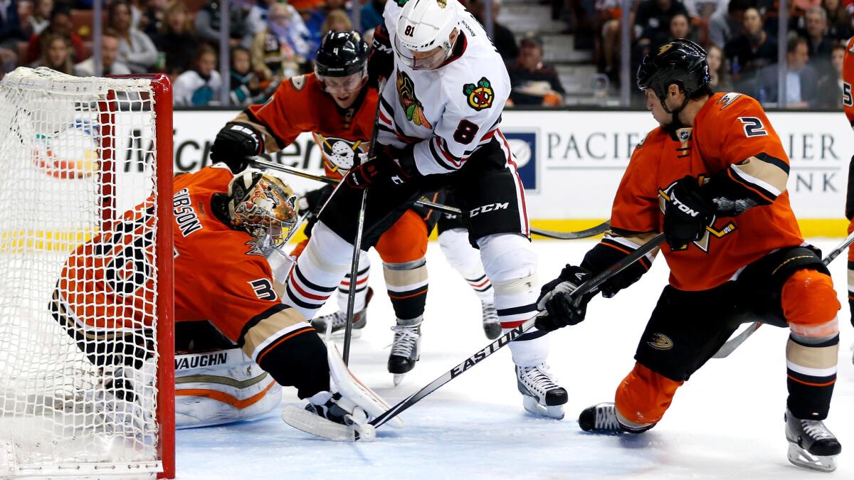 Ducks goalie John Gibson and defensemen Kevin Bieksa, right, and Cam Fowler try to prevent Blackhawks right wing Marian Hossa (8) from scoring in the second period Friday.