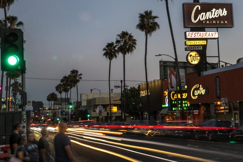 LOS ANGELES, CA-JUNE 20, 2022: Pedestrians wait to cross the street on Fairfax Ave. between Melrose Ave. and Beverly Blvd., the real-life setting that inspired Amazon's animated series "Fairfax." (Mel Melcon / Los Angeles Times)