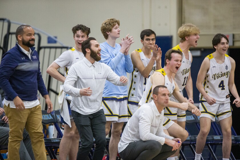 Marina's bench celebrates a basket during a Wave League boys' basketball game against Fountain Valley on Tuesday.