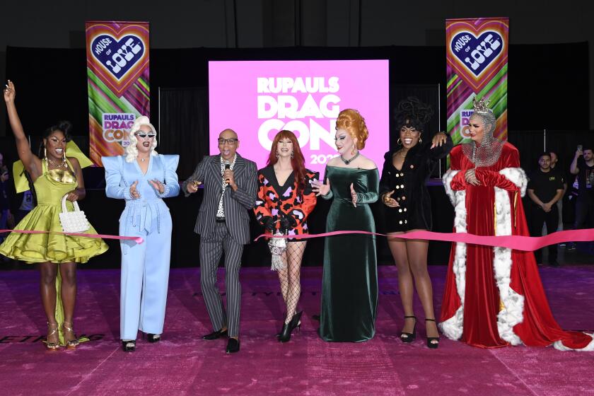 Ru Paul surrounded by five drag queens in a ribbon cutting ceremony at Drag Con
