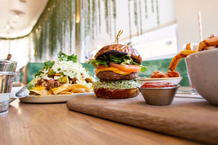 Los Angeles, CA., February 6, 2020 — A burger surrounded nachos, buffalo cauliflower and fries at Fresh on Sunset on Thursday, February 6, 2020 in Los Angeles, California. (Jason Armond / Los Angeles Times)