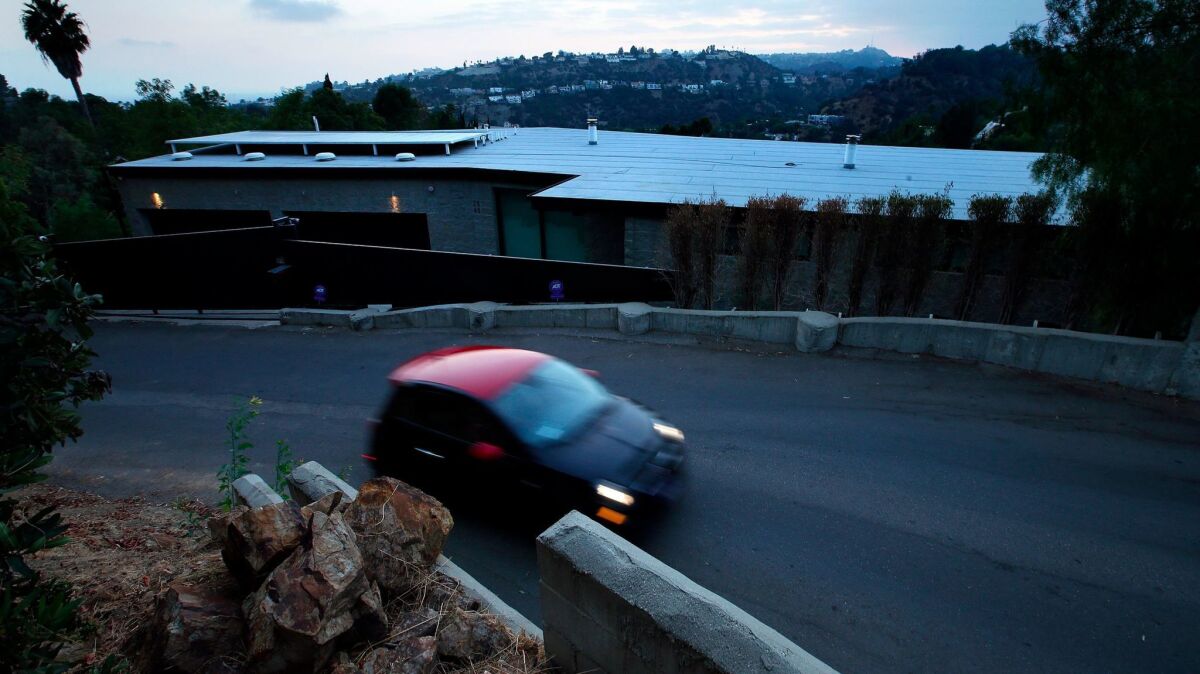 A motorist drives along La Cuesta Drive in the Hollywood Hills, past a home that was cited by the L.A. City Attorney for holding loud, raucous parties.