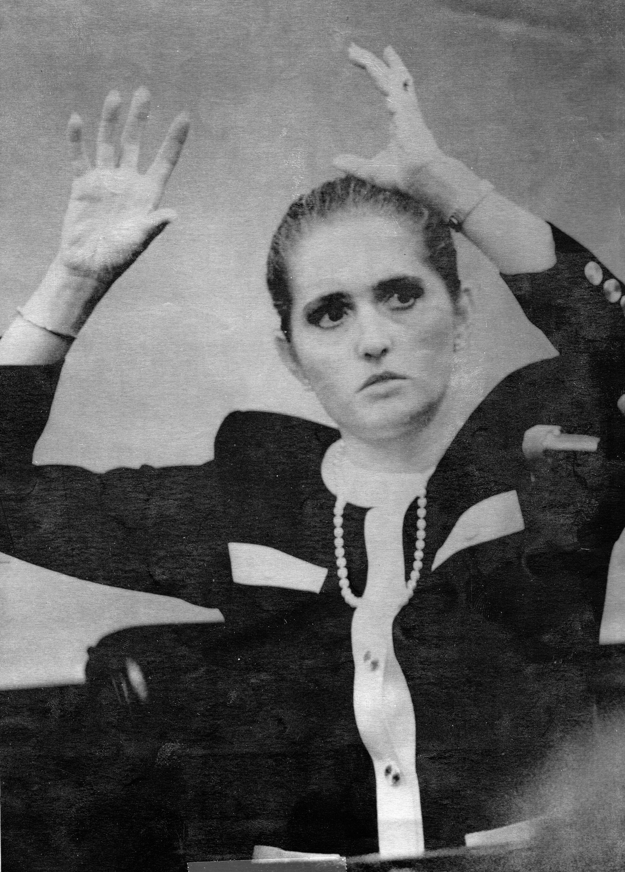 A black-and-white photo of Eileen Franklin-Lipsker holding her hands above her head as she answers questions in court