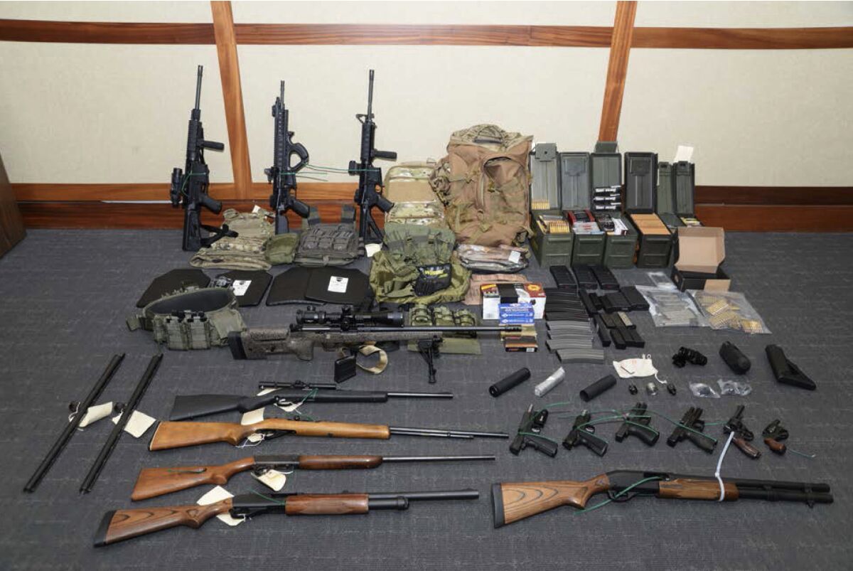 FILE - This undated file image provided by the Maryland U.S. District Attorney's Office shows a photo of firearms and ammunition that was in the motion for detention pending trial in the case against Coast Guard lieutenant Christopher Hasson, accused of stockpiling guns and targeting Supreme Court justices, prominent Democrats and TV journalists. Hasson has asked a federal appeals court to let him withdraw his guilty plea or else throw out his sentence of more than 13 years in prison. In a court filing Monday, June 8, 2020 a defense attorney argued that Christopher Hasson’s 160-month prison term was roughly four times longer than sentencing guidelines would have called for if U.S. District Judge George Hazel had not mistakenly applied a “terrorism enhancement” to the sentence. (Maryland U.S. District Attorney's Office via AP, File)