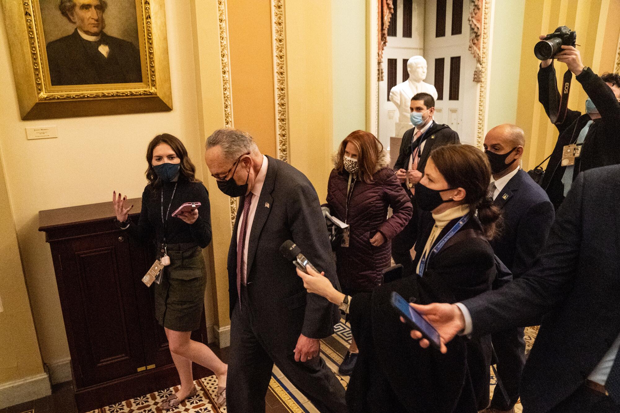 A group of reporters surround a senator in a Capitol hallway