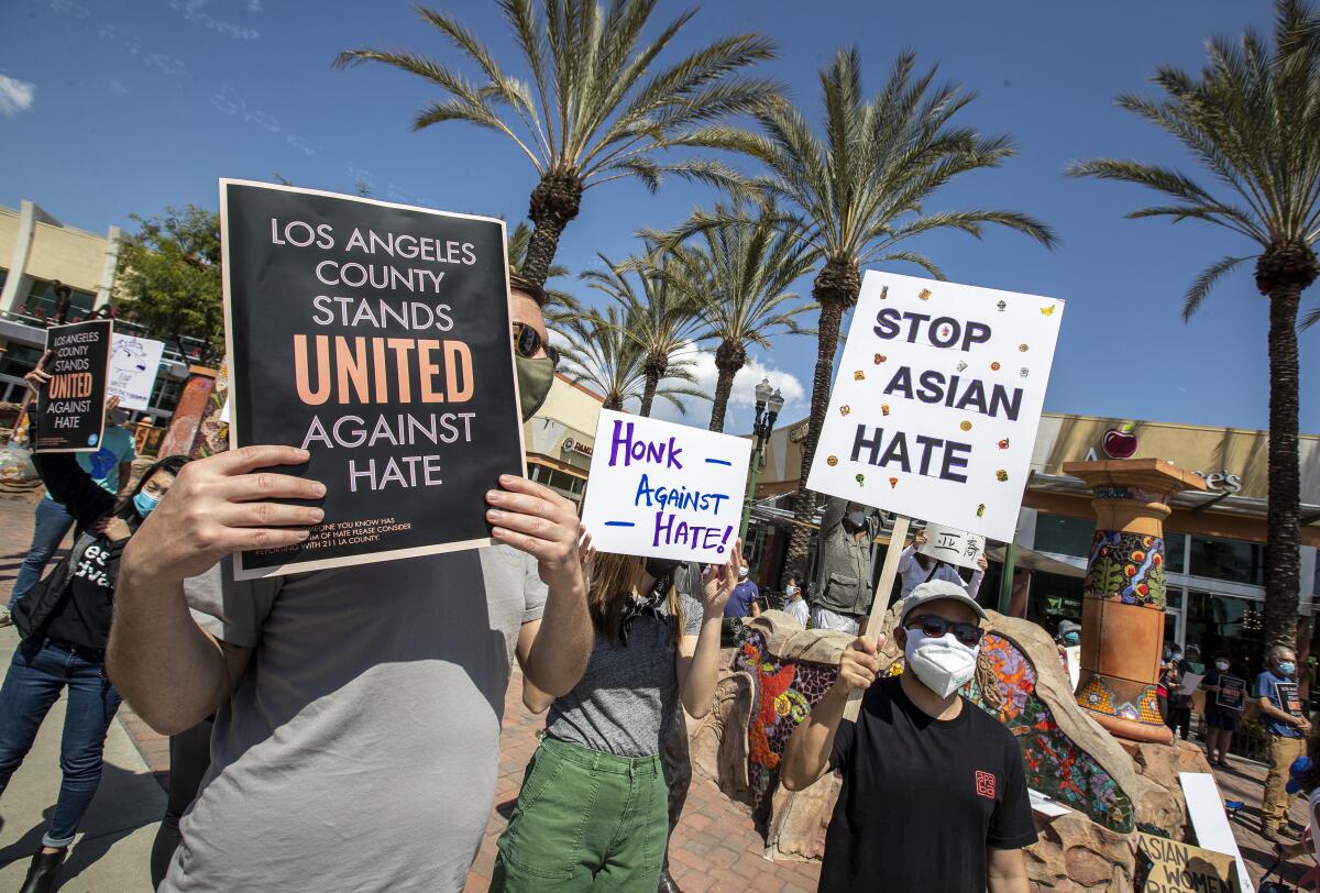 Demonstrators hold up signs protesting anti-Asian racism in Alhambra.