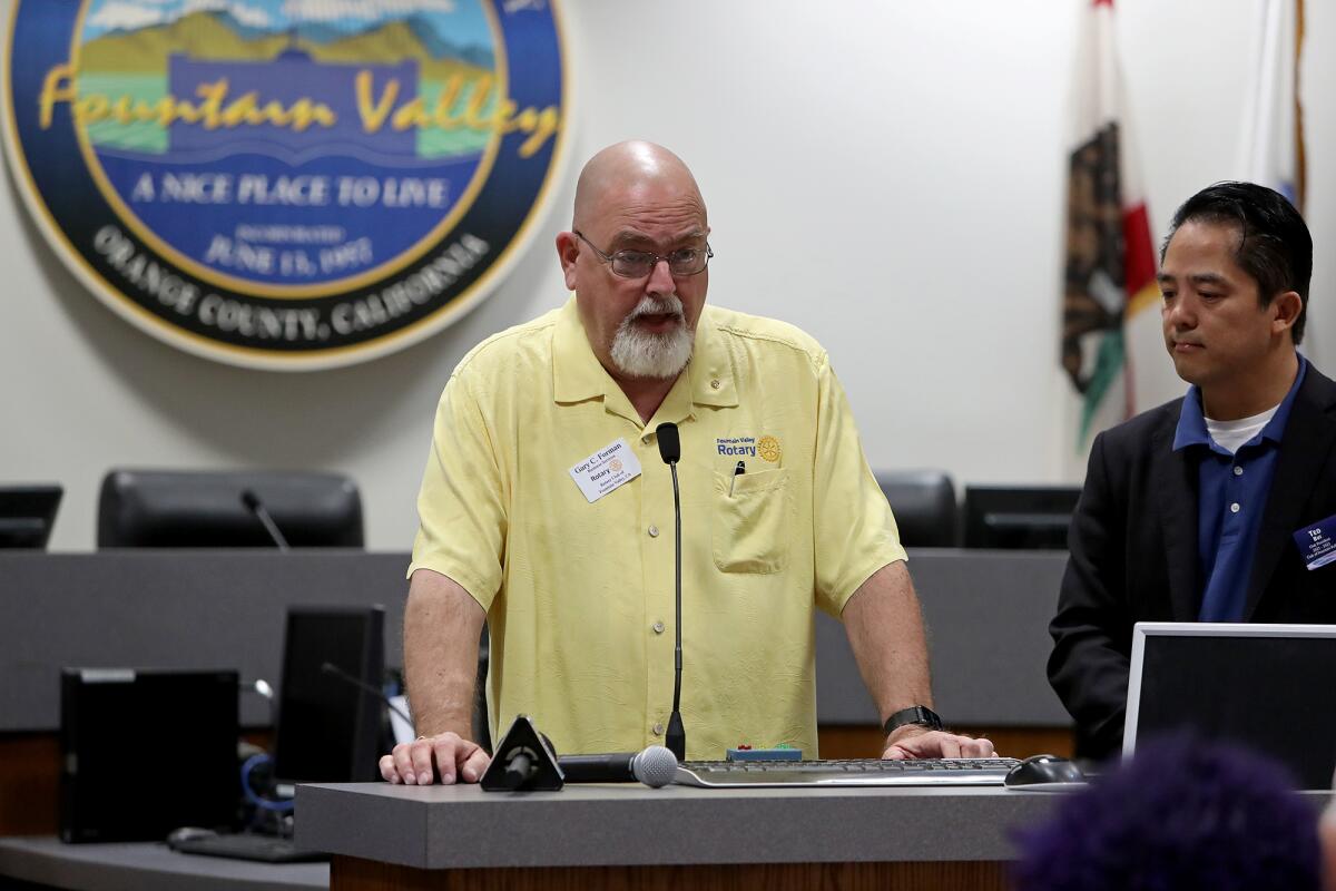 Gary Forman, left, who is treasurer of the Fountain Valley Rotary Club, speaks Friday about the "Walk for Vietnam" event.