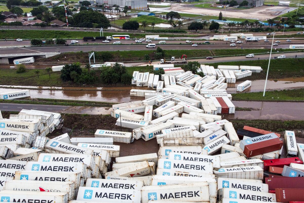 Shipping containers are strewn beside the N2 Highway in Durban, South Africa, Wednesday, April 13, 2022. Declaring a national state of disaster, South Africa has allocated $67 million to help those hit by floods that have killed at least 443 people in the eastern city of Durban and the surrounding KwaZulu-Natal province. (AP Photo/Shiraaz Mohamed)
