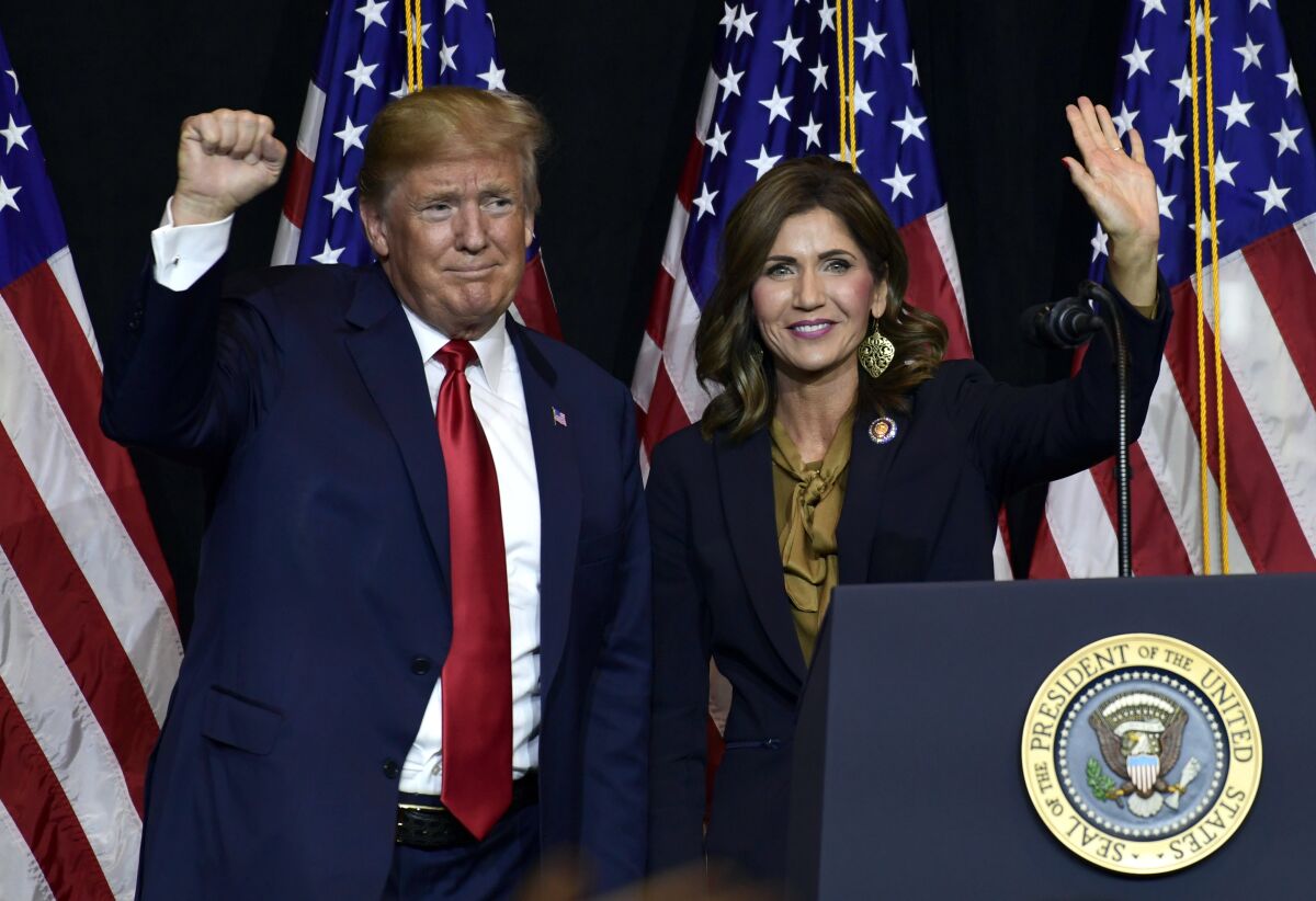 FILE - In this Sept. 7, 2018 file photo President Donald Trump appears with Gov. Kristi Noem in Sioux Falls, S.D. South Dakota officials said Wednesday, Aug. 12, 2020, they plan to erect a security fence budgeted around the official governor’s residence to protect Noem. Noem's office did not give specifics on any threats. The South Dakota Republican has championed a hands-off approach to managing the coronavirus crisis and also raised her national political profile in the past year, including tying herself more closely to Trump. (AP Photo/Susan Walsh, File)