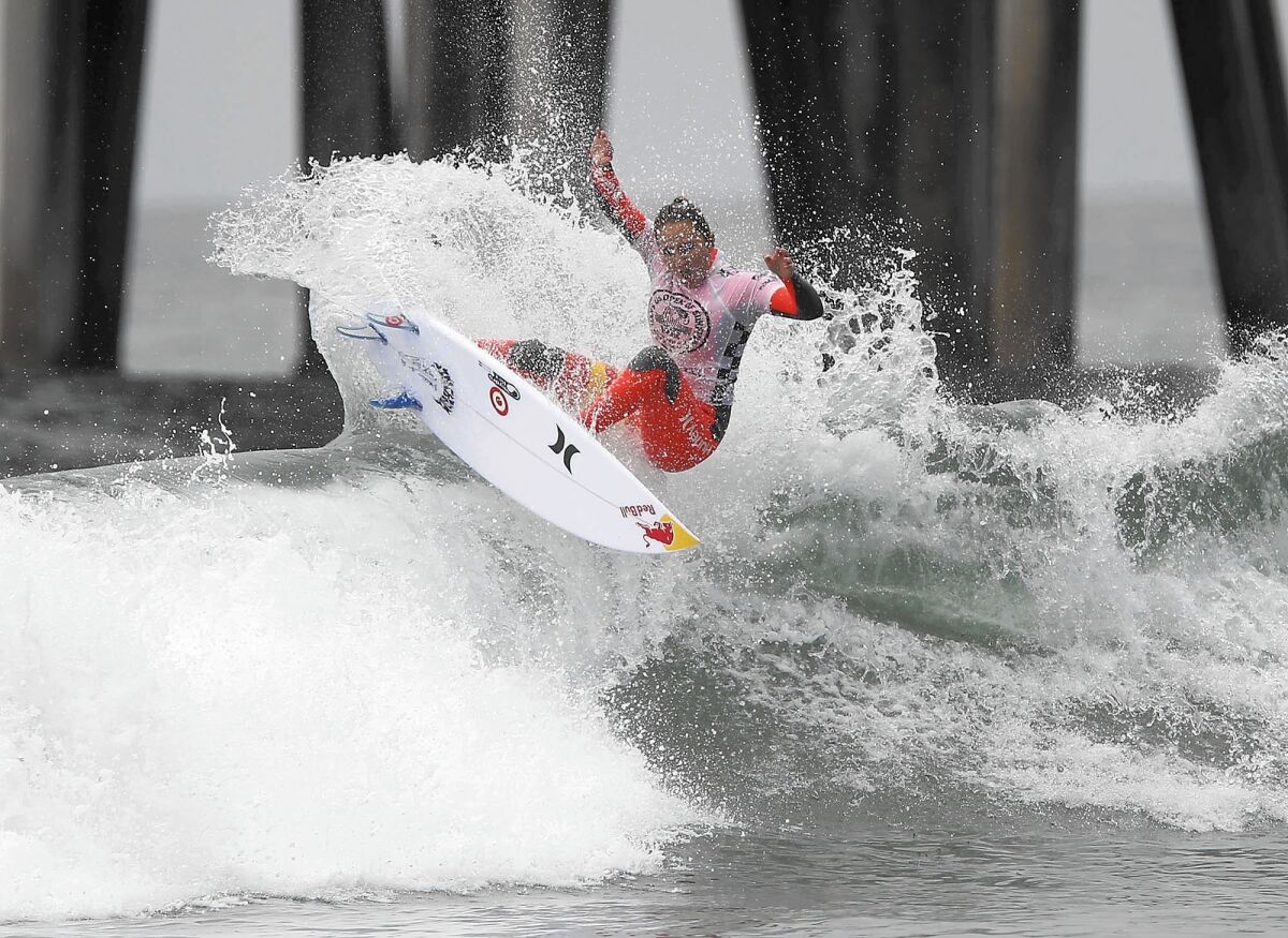 Hawaii's Carissa Moore pops a fins-free tail slide off the top of a set wave as she surfs in the women's championship final of the 2013 Van's US Open of Surfing at the Huntington Beach Pier, Sunday. Moore went on to win the championship final.