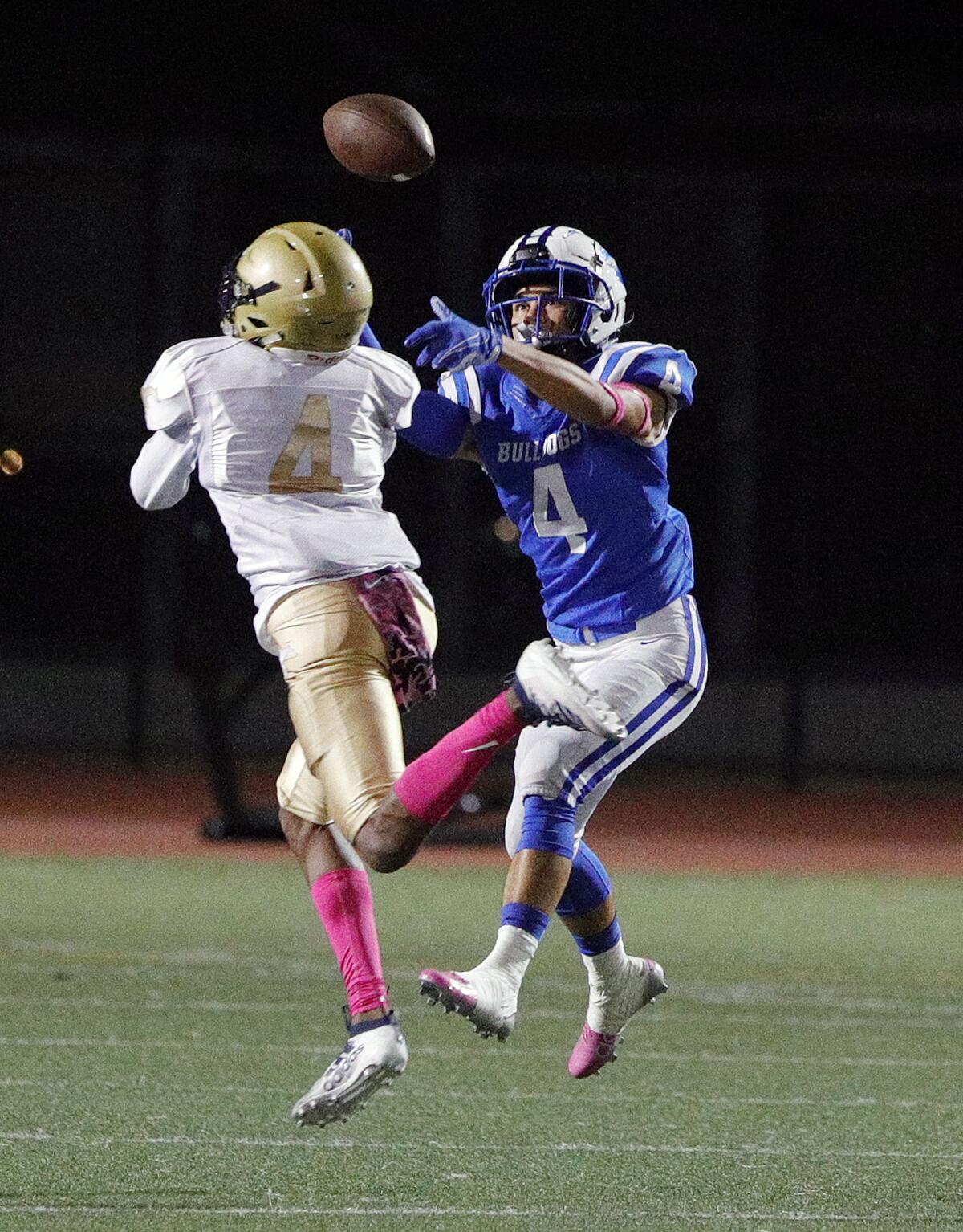 Muir passes deep right to awaiting Burbank defender Ian Miller just as Muir's Jamier Johnson gets under the ball for a pass that was nearly caught by both players in a Pacific League football game at Burroughs High School on Monday, October 14, 2019.