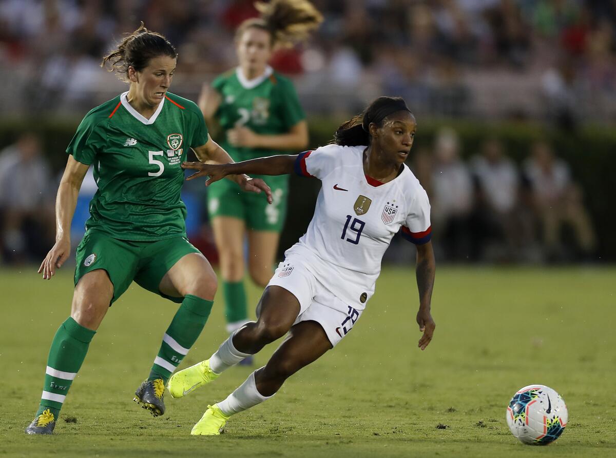 U.S. defender Crystal Dunn dribbles past Ireland defender Niamh Fahney 