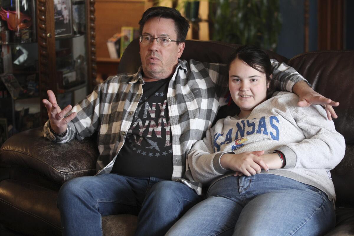 Rick Elskamp sits with his oldest daughter, Sheridan, in Topeka, Kan.
