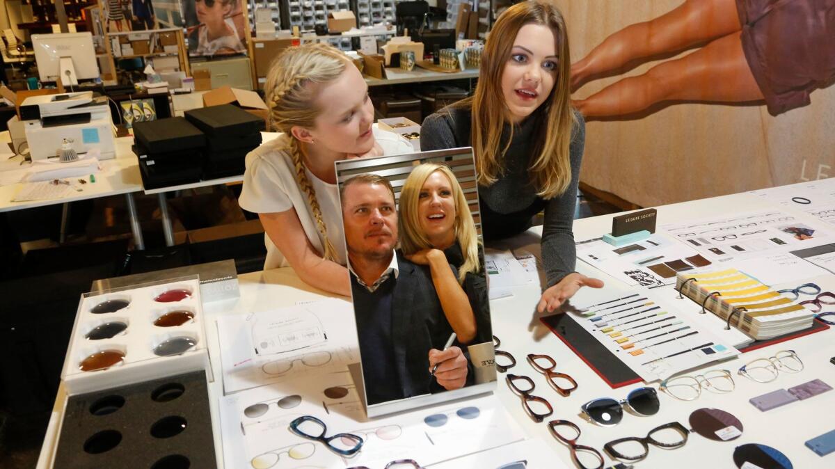 Auna, left, and Holland exchange design ideas with their father, Shane Baum, and his fiancee Erin MacAlpine at Leisure Society eyeware, a family-run business in Costa Mesa.